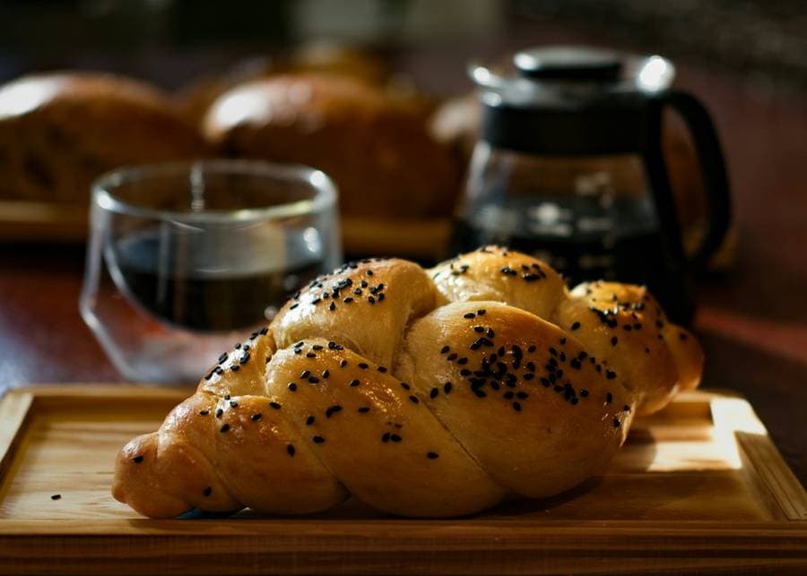 Freshly baked braided challah on a wooden board